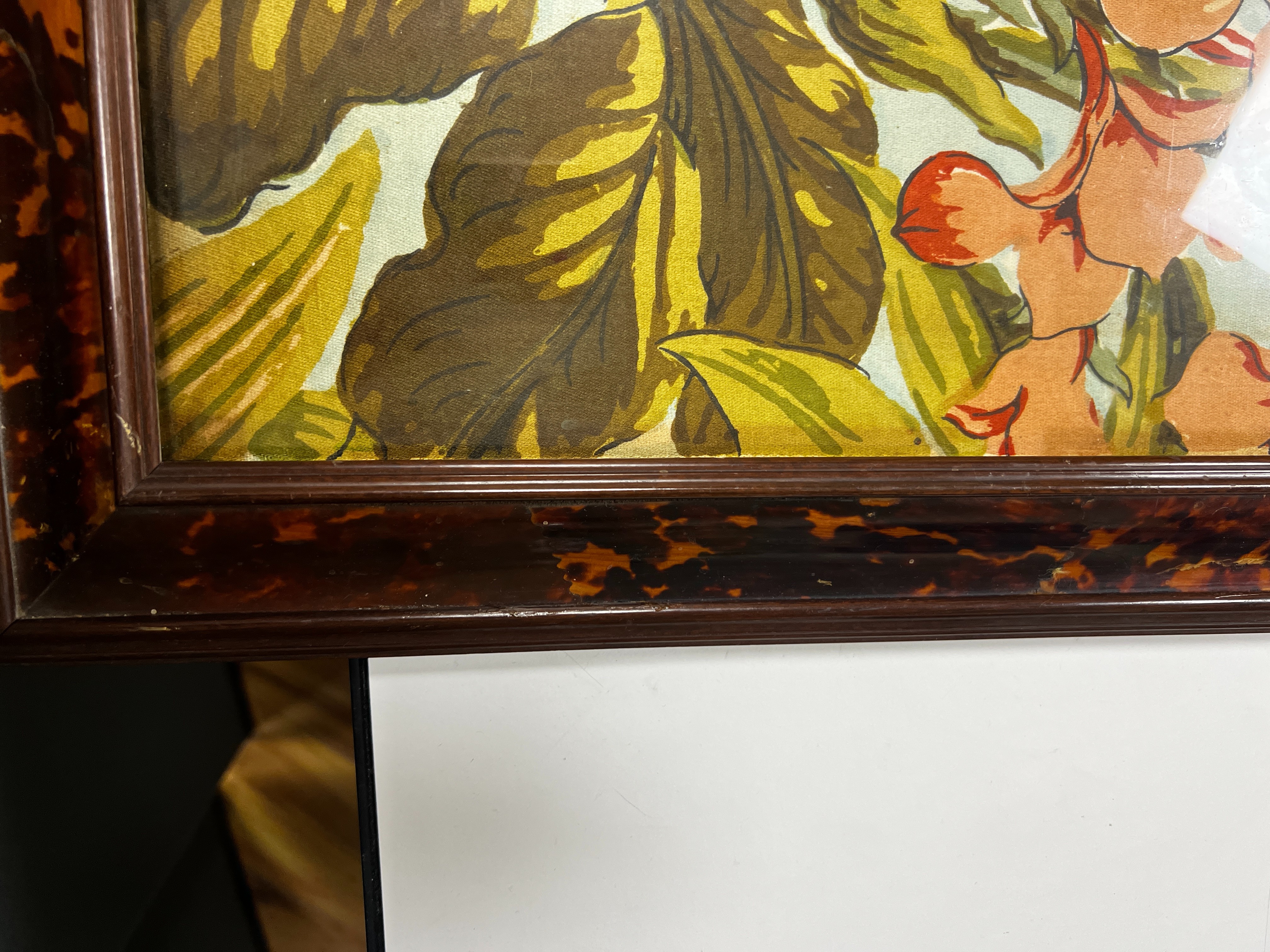A large rare tortoiseshell picture frame and exotic panel of printed fabric, 70 cms wide x 52 cms high including frame